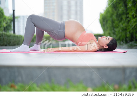 A portrait of happy Asian pregnant woman in yoga class club doing exercise at public garden park. Outdoor sport and recreation. activity with nature trees view. Having a baby. Family people lifestyle. A portrait of happy Asian pregnant woman in yoga class club doing exercise at public garden park. Outdoor sport and recreation. activity with nature trees view. Having a baby. Family people lifestyle. 115489199