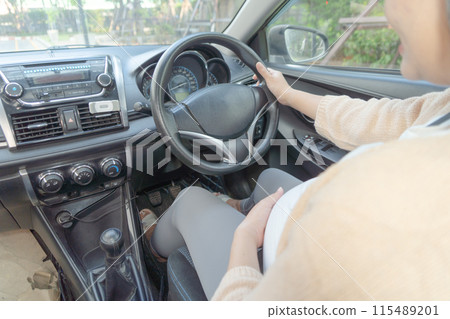 A Portrait of happy Asian pregnant woman driving a car vehicle. Having a baby. Family people lifestyle. Mom love. Journey. A Portrait of happy Asian pregnant woman driving a car vehicle. Having a baby. Family people lifestyle. Mom love. Journey. 115489201