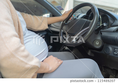 A Portrait of happy Asian pregnant woman driving a car vehicle. Having a baby. Family people lifestyle. Mom love. Journey. 115489207