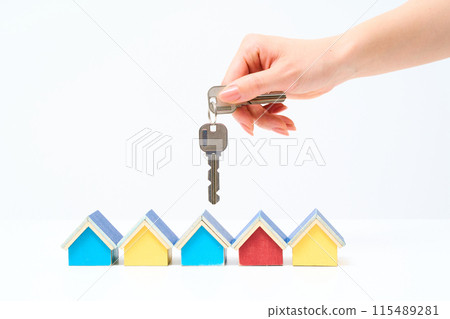 Woman's hand holding a house key 115489281
