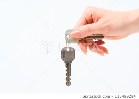 Woman's hand holding a house key 115489284