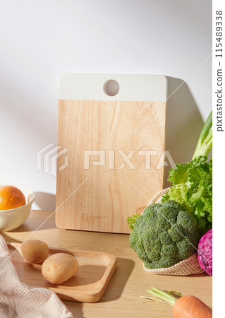 Advertising cooking pic with fresh vegetable and fruit ingredients in kitchen scene, from high angle shot. The counter contains some cooking utensils and fresh ingredients, blank space for displaying 115489338
