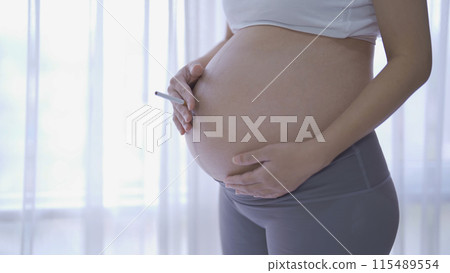 A Portrait of Asian pregnant woman smoking cigarette. Having a baby. Family people lifestyle. Mom love. A Portrait of Asian pregnant woman smoking cigarette. Having a baby. Family people lifestyle. Mom love. 115489554