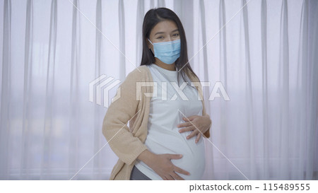 Depressed lonely Asian pregnant divorce woman with a mask for protecting covid-19 in bedroom at home. Having a baby. Family people lifestyle. Mom. quarantine Depressed lonely Asian pregnant divorce woman with a mask for protecting covid-19 in bedroom at home. Having a baby. Family people lifestyle. Mom. quarantine 115489555