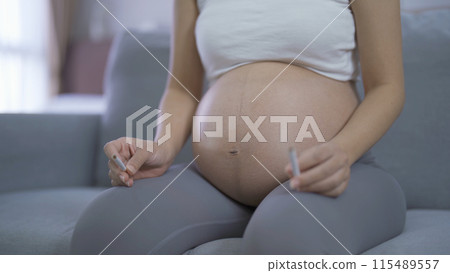A Portrait of Asian pregnant woman smoking cigarette. Having a baby. Family people lifestyle. Mom love. A Portrait of Asian pregnant woman smoking cigarette. Having a baby. Family people lifestyle. Mom love. 115489557
