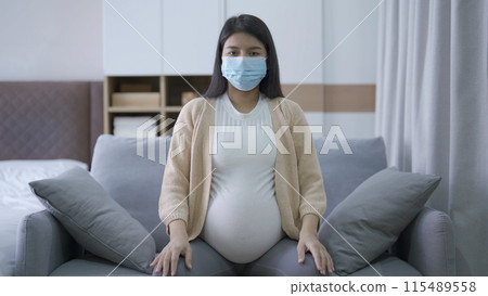 Depressed lonely Asian pregnant divorce woman with a mask for protecting covid-19 in bedroom at home. Having a baby. Family people lifestyle. Mom. quarantine Depressed lonely Asian pregnant divorce woman with a mask for protecting covid-19 in bedroom at home. Having a baby. Family people lifestyle. Mom. quarantine 115489558