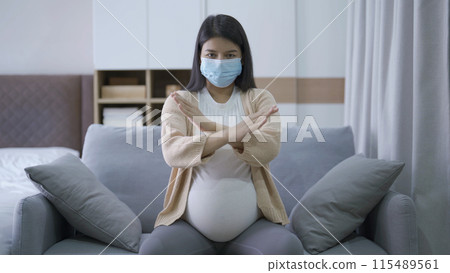 Depressed lonely Asian pregnant divorce woman with a mask for protecting covid-19 in bedroom at home. Having a baby. Family people lifestyle. Mom. quarantine 115489561