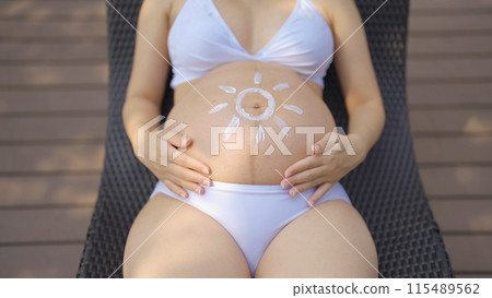 A portrait of happy Asian pregnant woman by the swimming pool. People lifestyle in travel holiday vacation concept. Relaxation. Having a baby. Family people lifestyle. Mom love. A portrait of happy Asian pregnant woman by the swimming pool. People lifestyle in travel holiday vacation concept. Relaxation. Having a baby. Family people lifestyle. Mom love. 115489562