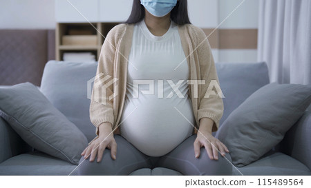 Depressed lonely Asian pregnant divorce woman with a mask for protecting covid-19 in bedroom at home. Having a baby. Family people lifestyle. Mom. quarantine Depressed lonely Asian pregnant divorce woman with a mask for protecting covid-19 in bedroom at home. Having a baby. Family people lifestyle. Mom. quarantine 115489564
