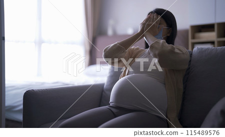 Depressed lonely Asian pregnant divorce woman with a mask for protecting covid-19 in bedroom at home. Having a baby. Family people lifestyle. Mom. quarantine 115489576