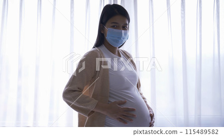 Depressed lonely Asian pregnant divorce woman with a mask for protecting covid-19 in bedroom at home. Having a baby. Family people lifestyle. Mom. quarantine 115489582