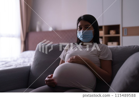 Depressed lonely Asian pregnant divorce woman with a mask for protecting covid-19 in bedroom at home. Having a baby. Family people lifestyle. Mom. quarantine 115489588