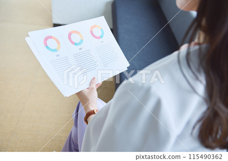 一位女士在辦公室的沙發上查看文件 115490362