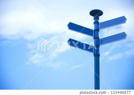 Blank direction sign with 4 arrowsn sky background. 115490877