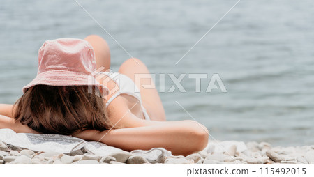 Unrecognizable positive woman in white bikini sunbathing or tanning on seaside beach during summer. happy tourist enjoying sun tan lying on beach chair lounge at luxury resort 115492015
