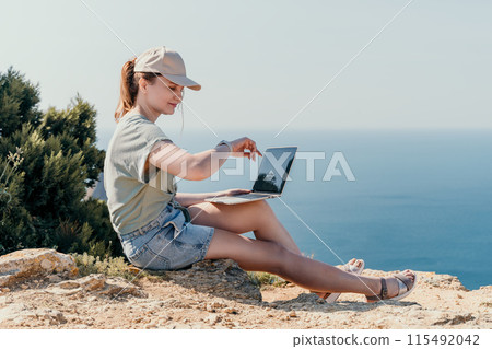 Woman sea laptop. Business woman, freelancer with laptop working over blue sea beach. Happy smiling girl relieves stress from work. Freelance, remote work on vacation, digital nomad, travel concept 115492042