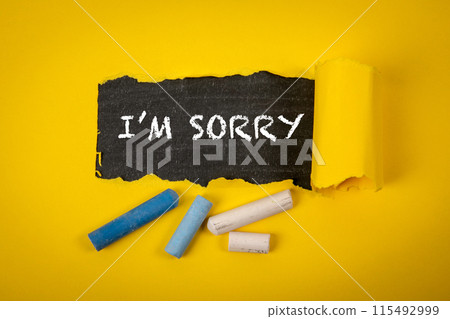 Im sorry. Text under torn yellow paper on a blackboard 115492999