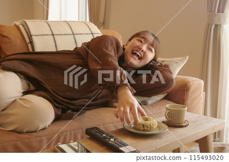 在客廳裡的沙發上放鬆的女人 在客廳裡的沙發上放鬆的女人 115493020