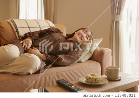 在客廳裡的沙發上放鬆的女人 在客廳裡的沙發上放鬆的女人 115493021