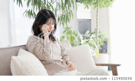 Woman crying in the living room Woman crying in the living room 115493039