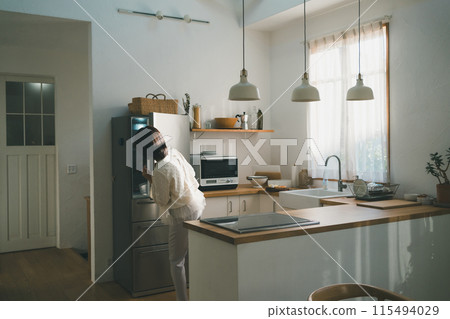 廚房裡的家庭主婦打開冰箱看看裡面有什麼。 115494029