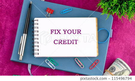Business, finacial and fix your credit concept. Copy space. Fix your credit symbol on a blank sheet of notepad in a composition with pens, paper clips, dollars and a green plant Business, finacial and fix your credit concept. Copy space. Fix your credit symbol on a blank sheet of notepad in a composition with pens, paper clips, dollars and a green plant 115496794