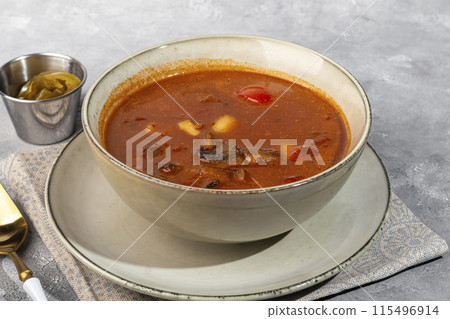 Tom yum soup with seafood, capers added nearby. 115496914