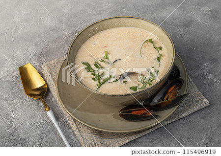 Seafood soup, garnished with arugula and mussels. 115496919