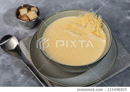 Cheese soup with croutons on a gray background. 115496925