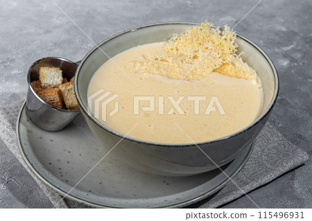 Cheese soup with croutons on a gray background. 115496931