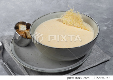 Cheese soup with croutons on a gray background. 115496938