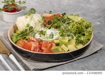 Salad bowl with rice, salmon, tomatoes, cucumbers and avocado. Poached egg. 115496995