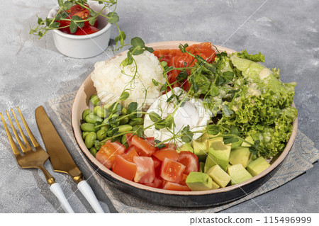 Salad bowl with rice, salmon, tomatoes, cucumbers and avocado. Poached egg. 115496999