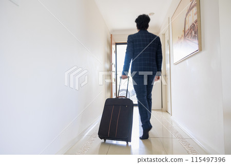 一名身穿西裝、提著手提箱走向入口的男子的後視圖 一名身穿西裝、提著手提箱走向入口的男子的後視圖 115497396