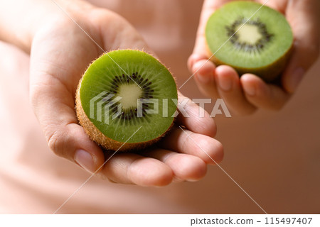 Green kiwi fruit holding by woman hand, Healthy eating 115497407