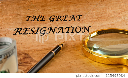 Text THE GREAT RESIGNATION, mass voluntary exodus from the workforce. THE GREAT RESIGNATION on papyrus in a composition with a magnifying glass, fountain pen and dollars without focus Text THE GREAT RESIGNATION, mass voluntary exodus from the workforce. THE GREAT RESIGNATION on papyrus in a composition with a magnifying glass, fountain pen and dollars without focus 115497984