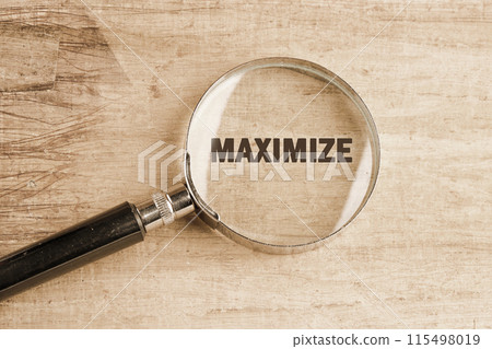 MAXIMIZE symbol. Business, minimalism concept. Copy space. MAXIMIZE word through a magnifying glass on papyrus MAXIMIZE symbol. Business, minimalism concept. Copy space. MAXIMIZE word through a magnifying glass on papyrus 115498019
