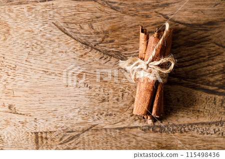 Cinnamon sticks dried tree bark spice on rustic wooden table background. Selective focus. 115498436