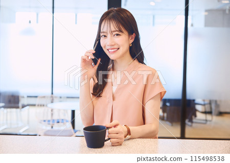 Woman making a phone call at the office pandori 115498538