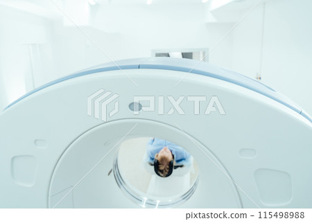 Blond mature woman enters into MRI capsule. Blond mature woman enters into MRI capsule. 115498988