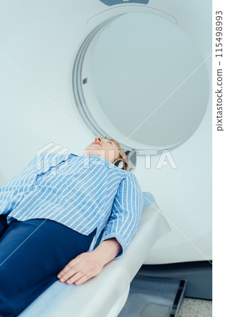 Blond mature woman enters into MRI capsule. Blond mature woman enters into MRI capsule. 115498993
