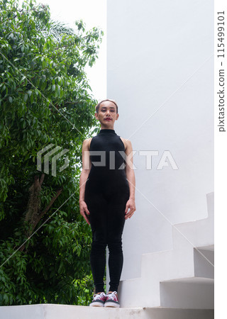 Full body shot of a queer LGBT community supporter man with mustache wearing lipstick and jumpsuit 115499101