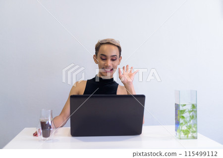 Queer LGBT community supporter man with mustache working in office, coffee and notebooks on desk 115499112