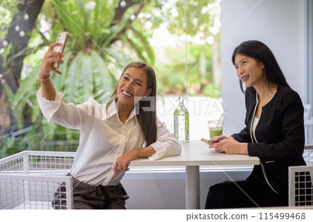 Two women are having a pleasant coffee meeting at a modern cafe with casual and professional vibes Two women are having a pleasant coffee meeting at a modern cafe with casual and professional vibes 115499468