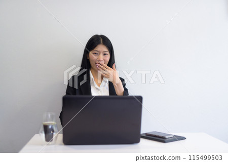 Asian businesswoman with laptop working in office, coffee and notebooks on desk Asian businesswoman with laptop working in office, coffee and notebooks on desk 115499503