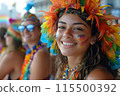 A woman wearing a colorful headdress and a colorful outfit is smiling 115500392