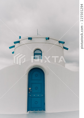 A blue door with a lock sits in front of a white building. The door is the only visible part of the building, and it is blue in color. 115501294