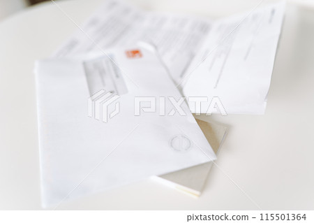 postal envelope with sheet of paper, letter on white table 115501364