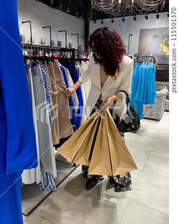 Shopping woman, women's fashion clothes in a store, boutique. Woman choosing clothes in a store Shopping woman, women's fashion clothes in a store, boutique. Woman choosing clothes in a store 115501370