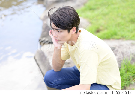 Young man standing by the water 115501512
